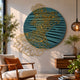 Auramesh Teal Blue-II Metal Winged Circular Geometric Wall Art by Giant Sculptures displayed above a mid-century armchair and wooden console in a sunlit living room.
