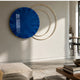 Eclipse Luxe Midnight Blue Circular Ring Wall Art by Giant Sculptures, a glossy blue disc with overlapping gold rings, mounted in a modern living room.