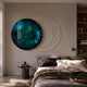 Eclipse Luxe Emerald Circular Ring Wall Art by Giant Sculptures, glossy teal disc with overlapping gold rings, displayed above a bed in a modern bedroom.