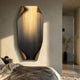Celestial Midnight Gradient Edge Folded Abstract Metal Wall Art by Giant Sculptures mounted in a bedroom, with gold streaks fading into black above a bed.