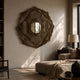 Sculptura Mirror Sand Beige Floral Round Metal Wall Art displayed on a neutral living room wall above a dark sideboard with lamp and beige sofa.