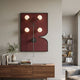 Axial Elegance Burgundy Symmetrical Metal Wall Art by Giant Sculptures displayed above a walnut sideboard with books and an olive plant in a modern hallway.