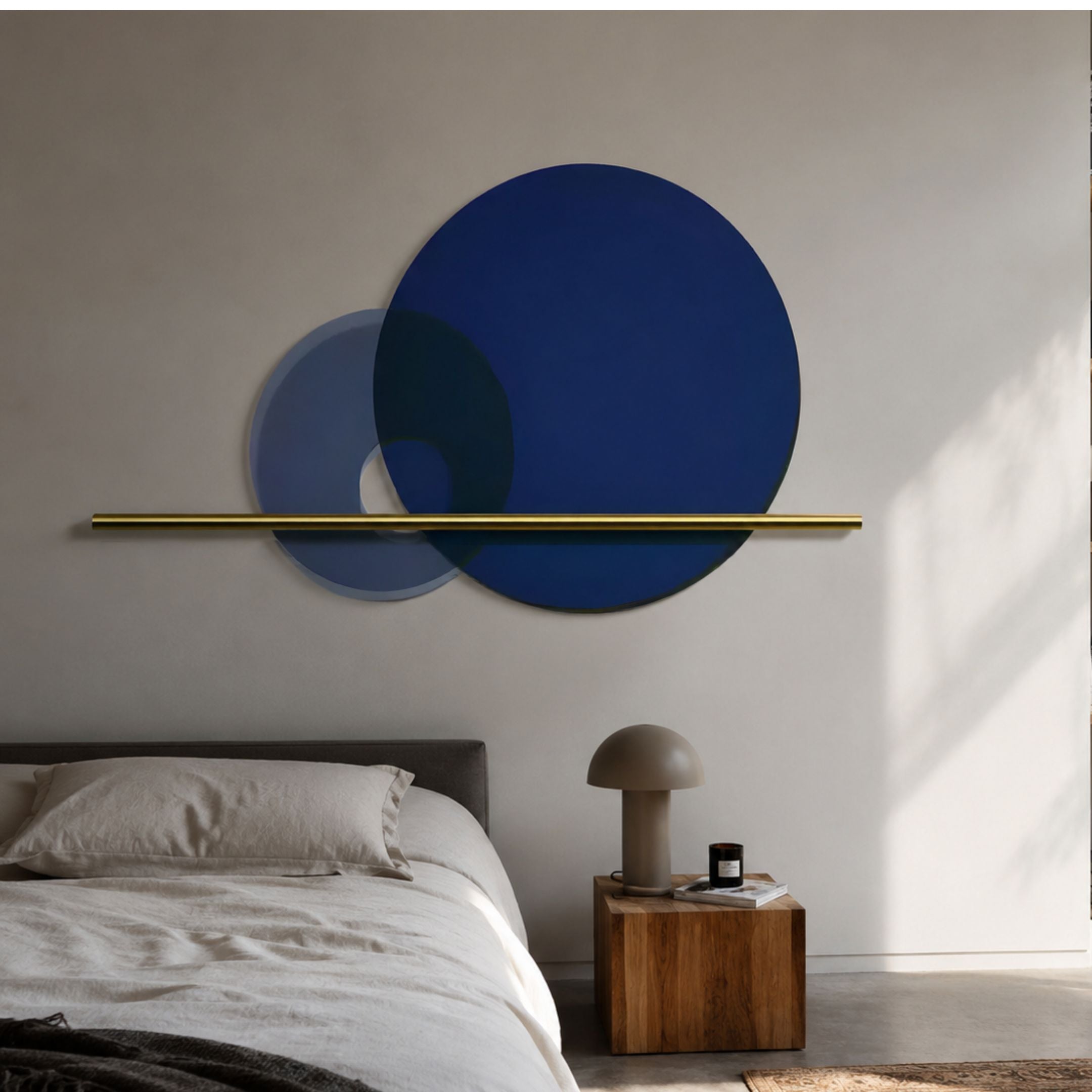 Luna Forma Midnight Blue Round Brass Accent Wall Art mounted above a grey upholstered bed with a wooden cube nightstand and mushroom lamp.