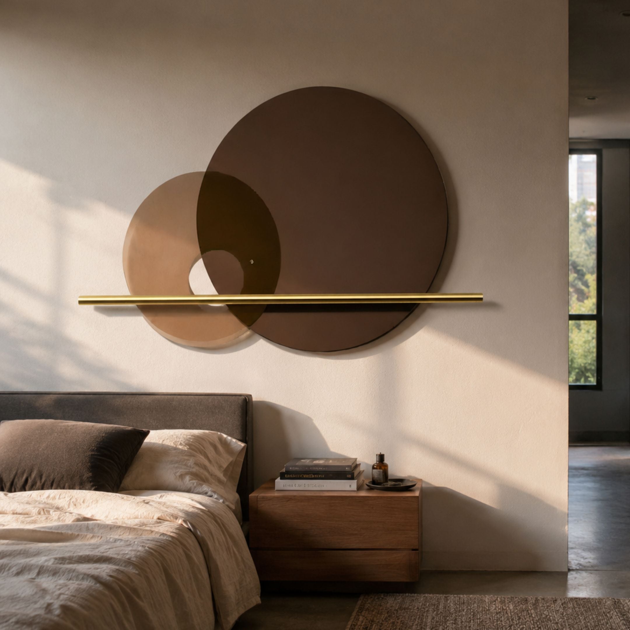 Luna Forma Mocha Brown Round Brass Accent Wall Art by Giant Sculptures displayed above an upholstered bed and wooden nightstand in a sunlit bedroom.