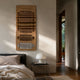 Strata Brown Vertical Folded Grid Metal Wall Art by Giant Sculptures, stacked gold panels with a silver base panel, mounted above a bed beside a dome lamp.