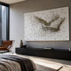 Flock Golden Flight Sculpture Metal 3D Wall Art by Giant Sculptures, gold figurines forming a bird in flight on white, above a black console in a modern bedroom.