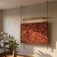 Celestique Prosperity Script Framed Long Hanging LED Wall Art by Giant Sculptures, gold calligraphy on deep red in a copper rod frame, mounted in a sunlit living room.