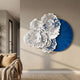 Aurum Flora White Petals Cobalt Blue Metal Wall Art with layered white floral cut-outs over a round blue disc, mounted above a beige sofa in a living room.