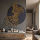 Cellura Deep Purple Geometric Layered Gold Wired Metal Wall Art mounted above a wooden console with books in a modern living room with armchair.