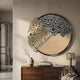 Aurelio Left Metallic Layered Textured Round Wall Art by Giant Sculptures, mounted above a walnut sideboard with vase, books, and glass lamp in a modern interior.
