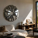 Halo Chrome Segment Circle 3D Metal Wall Art by Giant Sculptures mounted above a wood console in a sunlit living room with a linen sofa.
