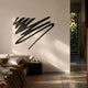 Oscura Wave Crest Black Abstract Metal Wall Art by Giant Sculptures displayed above a dark bedside table in a minimalist bedroom with cream walls and linen bedding.