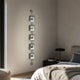 Papilio Butterfly Vertical Blue Modern 3D Wall Art by Giant Sculptures, five glass-framed butterfly specimens on an iron rod, displayed beside a bed.