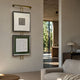 Artisera Quadratic Harmony dual frame wall art with black and gold square frames on a vertical rod with built-in LED light, displayed in a modern living room.