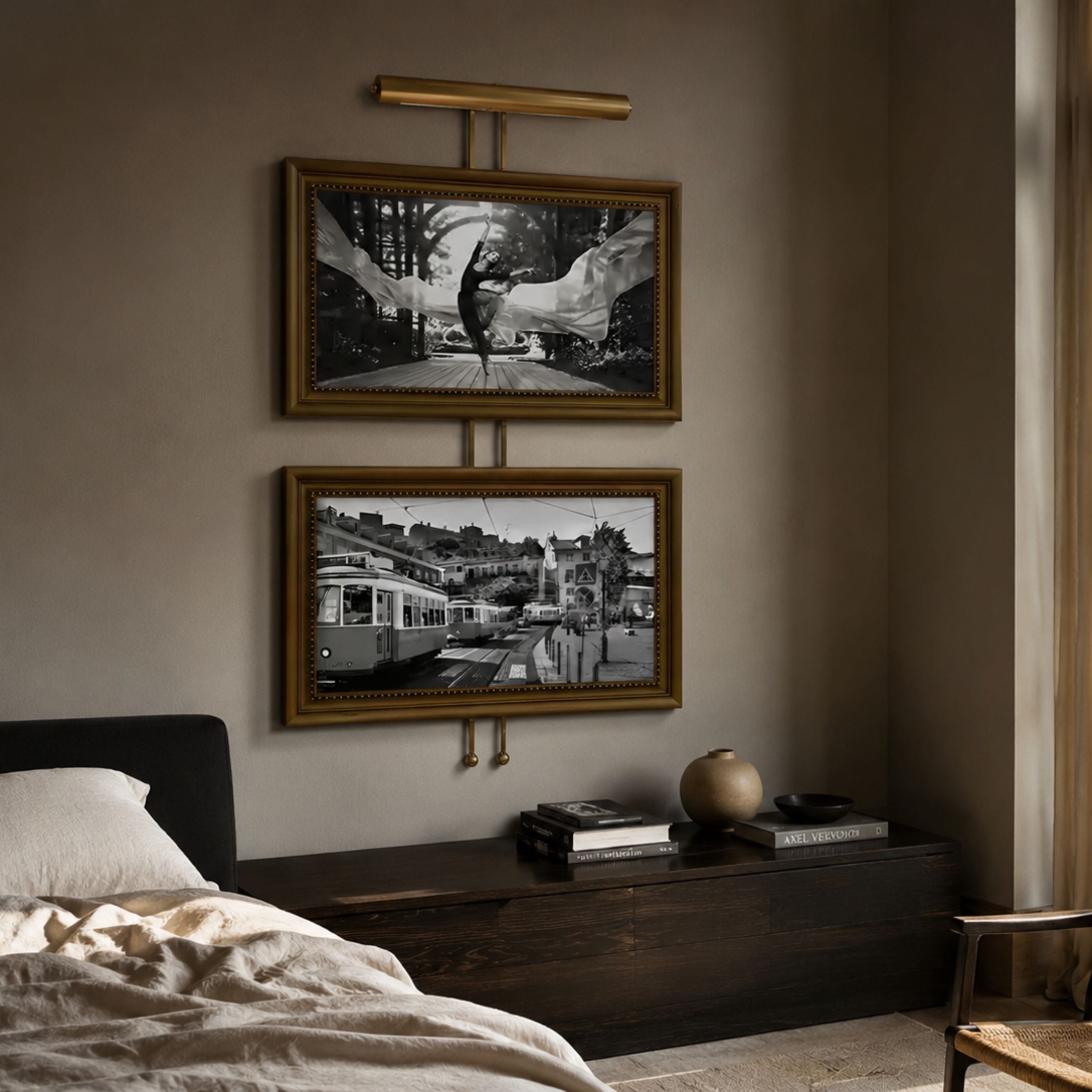 Artisera Ballet Noir Luxe Dual Frame Built-In Light Wall Art mounted above a dark wood console in a bedroom, with a ballet dancer image above a monochrome tram scene.