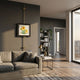 Ecliptica Sunflower Botanical Illustration Gold Frame Wall Art by Giant Sculptures mounted on a dark grey wall above a linen sofa in a modern living room.