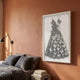 Flutter Charcoal & White Butterfly Dress 3D Wall Art in a white frame on a terracotta bedroom wall above a grey linen bed with a black wall lamp.