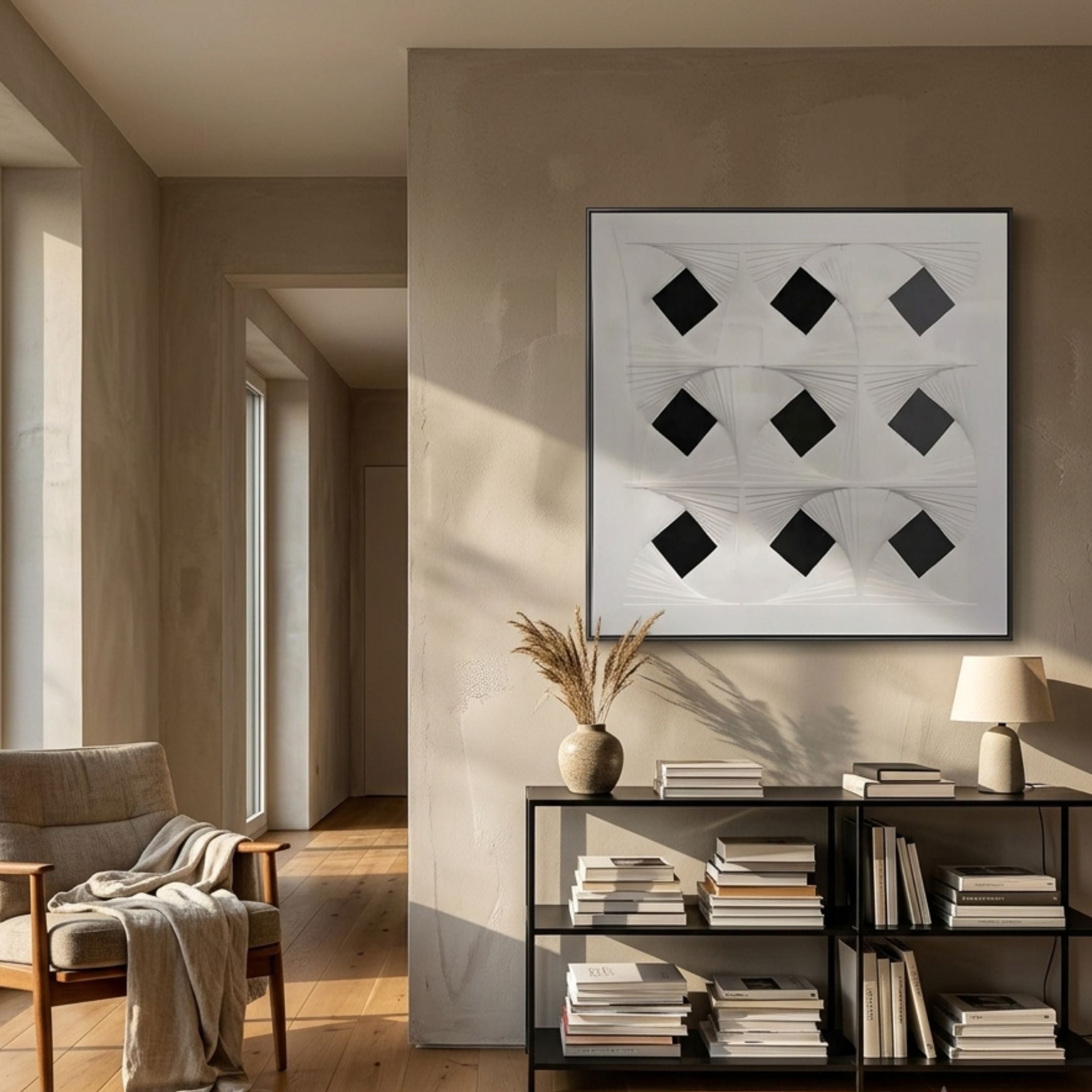 Prismatics Black Diamond Patterned Cardboard Wall Art by Giant Sculptures, displayed above a black console with books in a sunlit neutral living room.