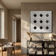 Prismatics Black Diamond Patterned Cardboard Wall Art by Giant Sculptures, displayed above a black console with books in a sunlit neutral living room.