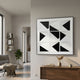 Prismatics Black & White Geometric Cardboard Wall Art by Giant Sculptures displayed in a modern living room above a wooden console with dried grasses.