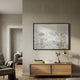 Silvienne Handcrafted Silk Artwork with gold foil highlights, framed in black above a wooden console with lamp and books in a neutral-toned living room.
