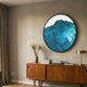 Auric IV Blue Wave Abstract Copper Wire Enamel Round Wall Art by Giant Sculptures displayed above a mid-century teak sideboard with dried grasses and brass lamp.