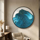 Auric II Blue Wave Abstract Copper Wire Enamel Round Wall Art by Giant Sculptures displayed above a wooden console and armchair in a neutral living space.