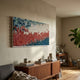 Avaris Frameless 3D Ceramic Wall Art by Giant Sculptures with blue, red, and white cone-textured wave, mounted above a walnut sideboard in a sunlit living room.