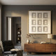 Lustella Black & White Plaster Statue Cardboard Square Wall Art by Giant Sculptures mounted above a walnut sideboard with vase, lamp, and black leather chair.