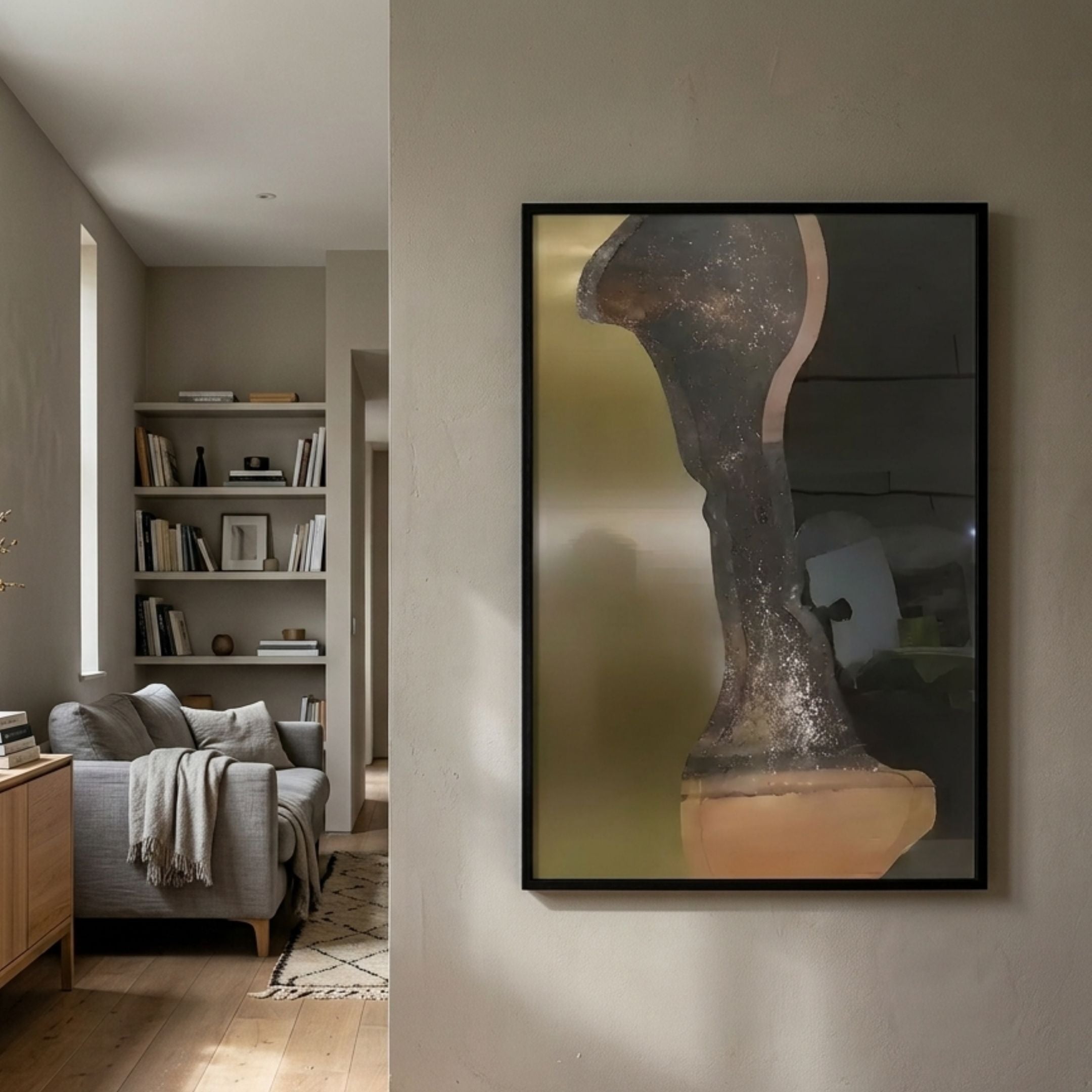 Astrid Metallic Abstract Silhouette Wall Art by Giant Sculptures in a black frame, displayed on a neutral hallway wall beside a reading nook with bookshelves and grey sofa.