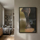 Astrid Metallic Abstract Silhouette Wall Art by Giant Sculptures in a black frame, displayed on a neutral hallway wall beside a reading nook with bookshelves and grey sofa.