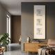 Lustre White Plaster Statue Vertical Decorative Wall Art by Giant Sculptures displayed on a grey living room wall above an oak sideboard with vase and leather chair.