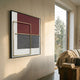Optique Spiral Black & Red Square Wall Art by Giant Sculptures displayed on a cream wall in a sunlit living room beside a large window and linen-draped sofa.