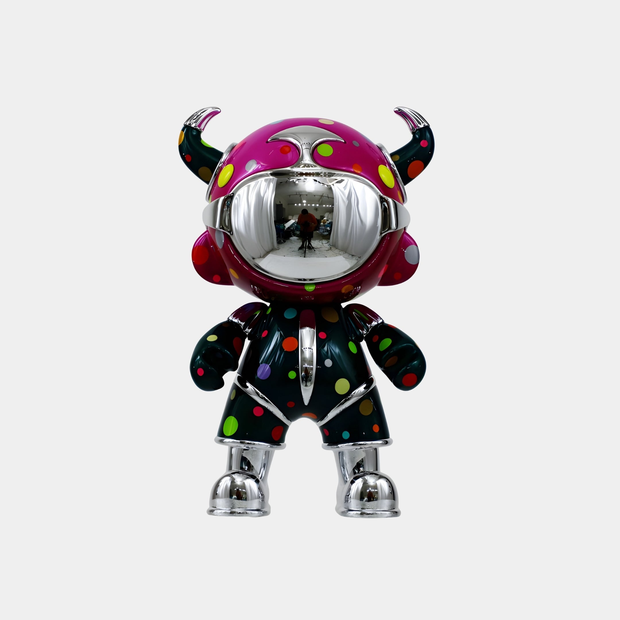 The Giant Sculptures Midnight Confetti Suit Astro Devil Figure (48cm) features a chrome, reflective face, black polka-dot outfit, and pink horned helmet—a striking contemporary piece ideal for bold pop-art decor.