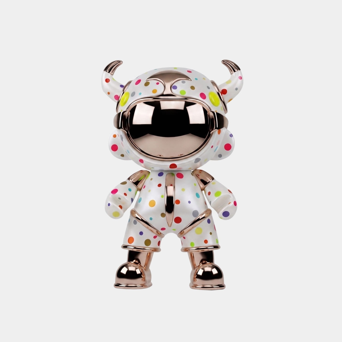 The White Confetti Suit Astro Devil Figure by Giant Sculptures stands 48cm tall, featuring a shiny metallic finish, round mirrored face, white suit with colorful polka dots, and horned helmet—a striking piece of contemporary art.