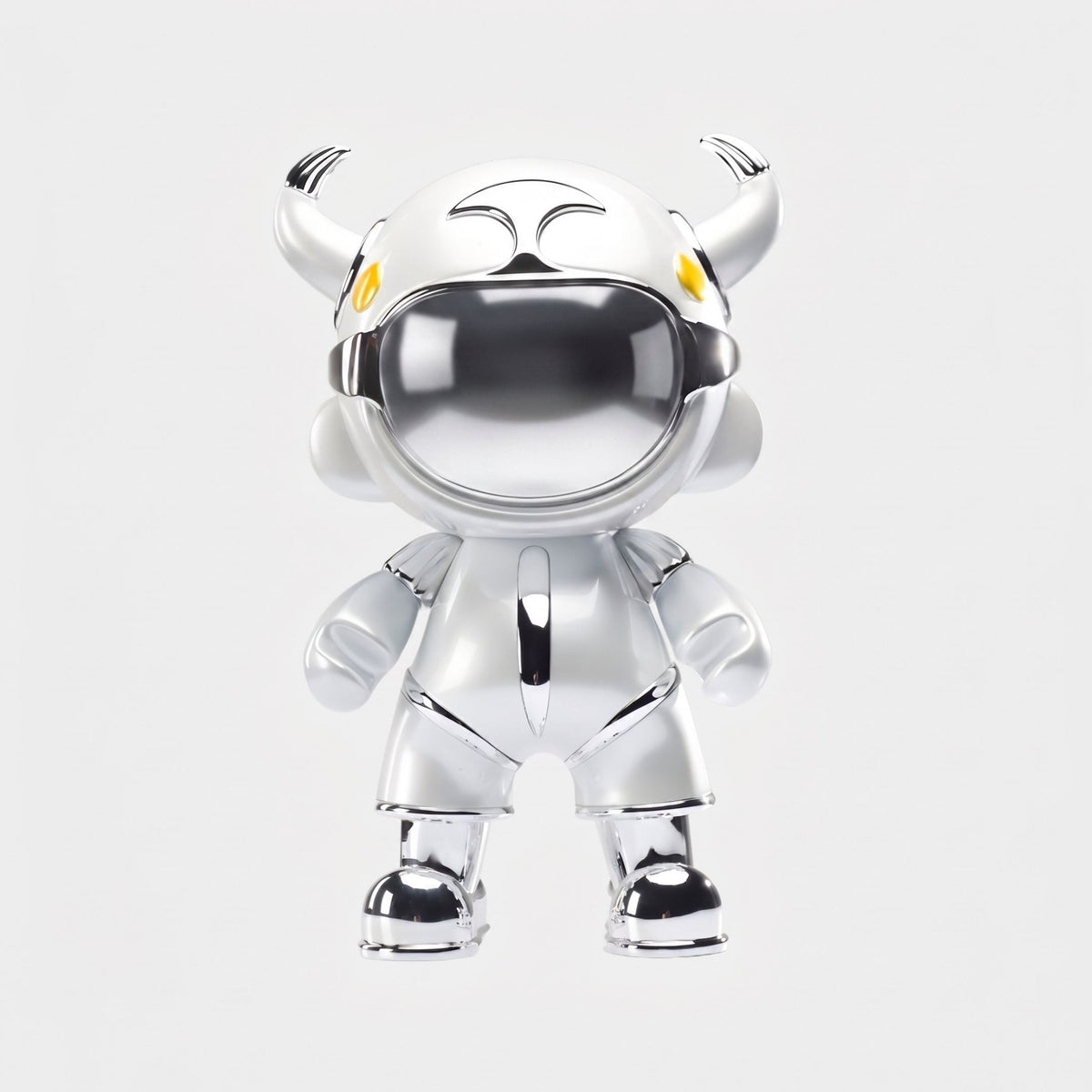 The Giant Sculptures Silver Suit Astro Devil Sculpture (80cm) features a shiny silver finish, mirrored chrome visor, large helmet with two small horns, yellow eyes, and rounded limbs, standing upright against a plain white background.
