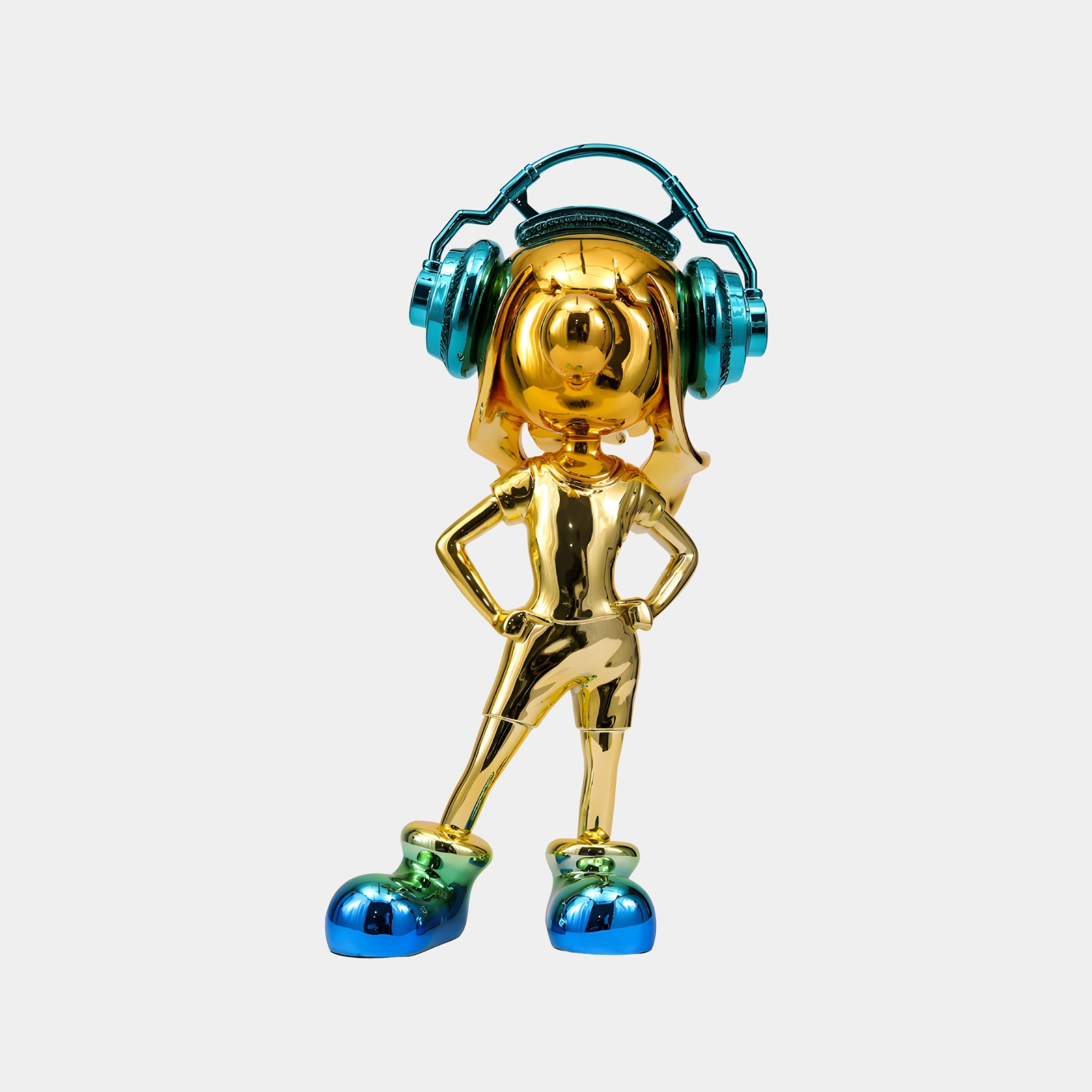The Gold Teal Vibella Electroplated Figure (60cm) by Giant Sculptures features a confident person with hands on hips, oversized teal headphones, and matching shoes—presented in gold against a white background.