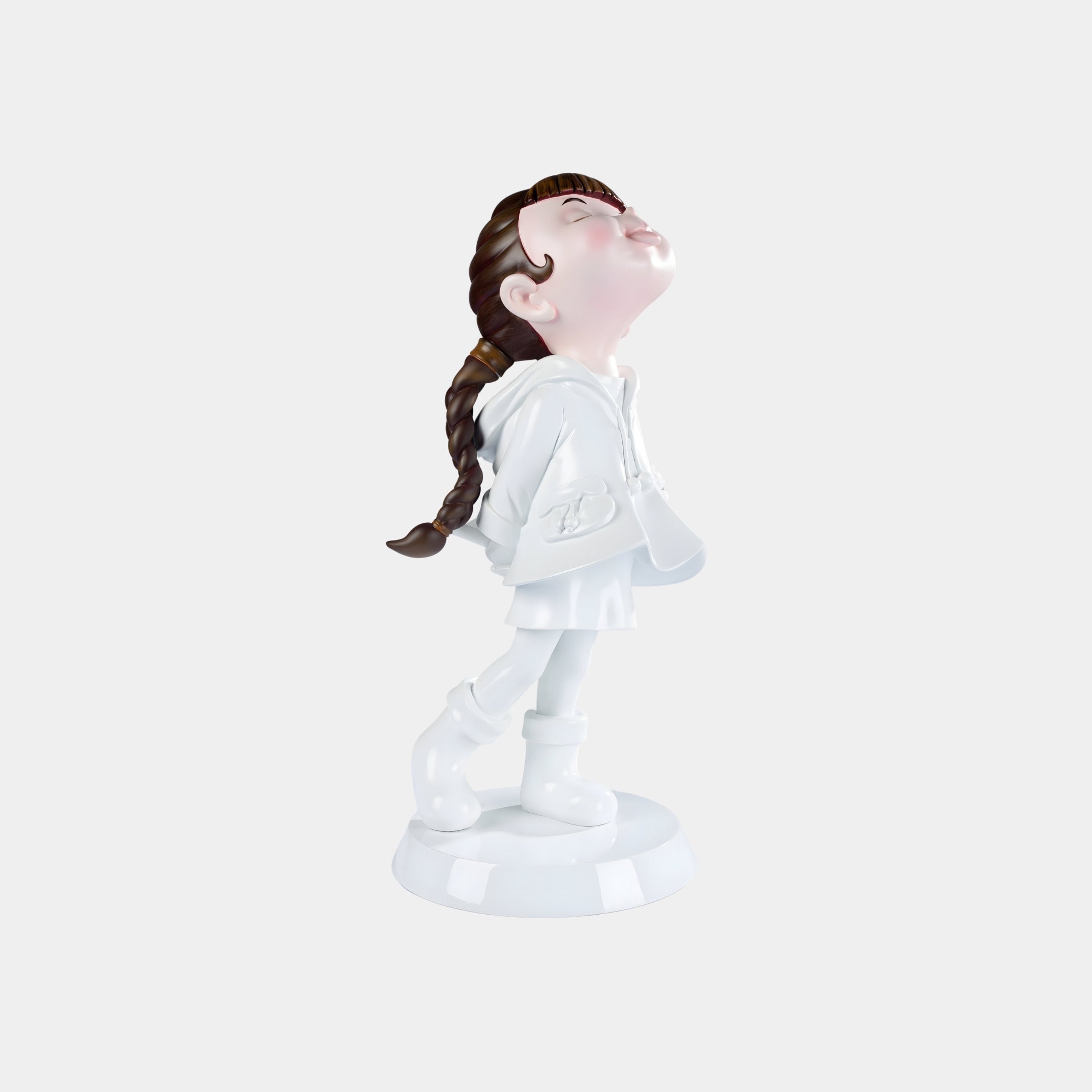 The Giant Sculptures Pure White Lulabelle Sculpture - 60cm features a girl with brown braided hair in a white raincoat and boots, standing on a round base, eyes closed and serene, capturing a peaceful charm.
