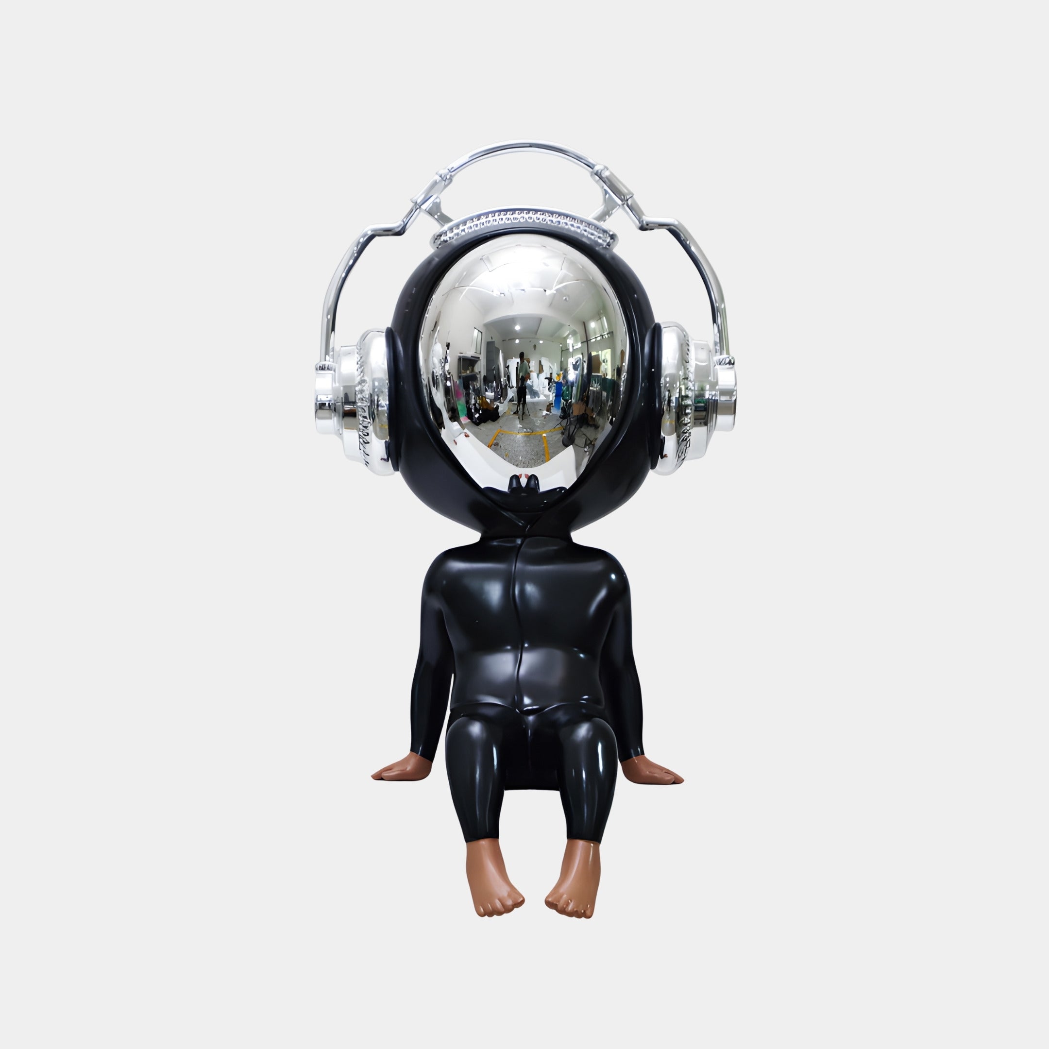The Midnight Black Alien Beats Figure (55cm) by Giant Sculptures features a futuristic chrome head with silver headphones, black body, and bare feet. This pop art decor piece reflects people and lights for a striking modern touch.
