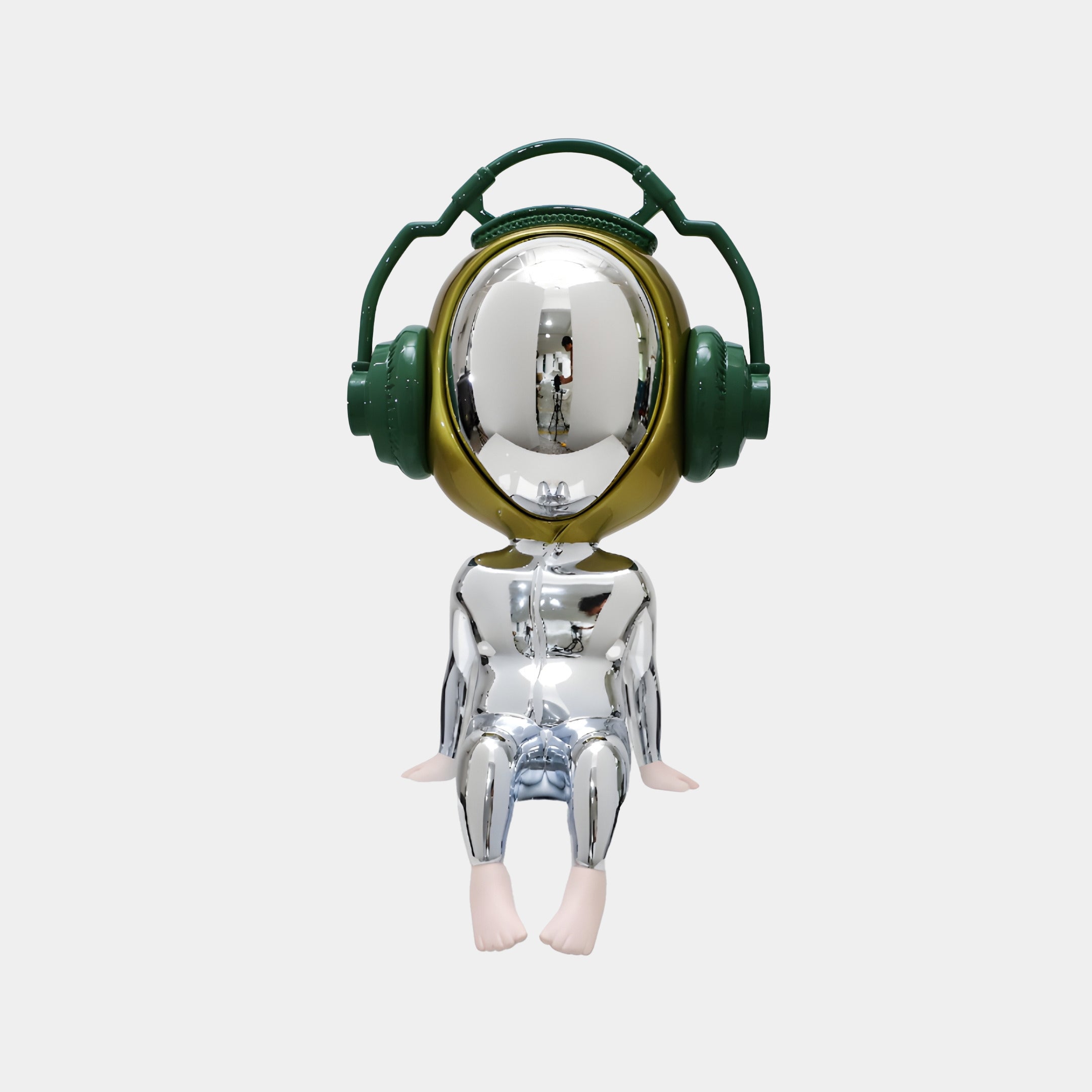 A shiny, metallic humanoid with a round reflective head, oversized green headphones, and bare feet sits with hands on its knees—the 55cm Mirror Chrome Alien Beats Figure by Giant Sculptures for sci-fi design lovers.