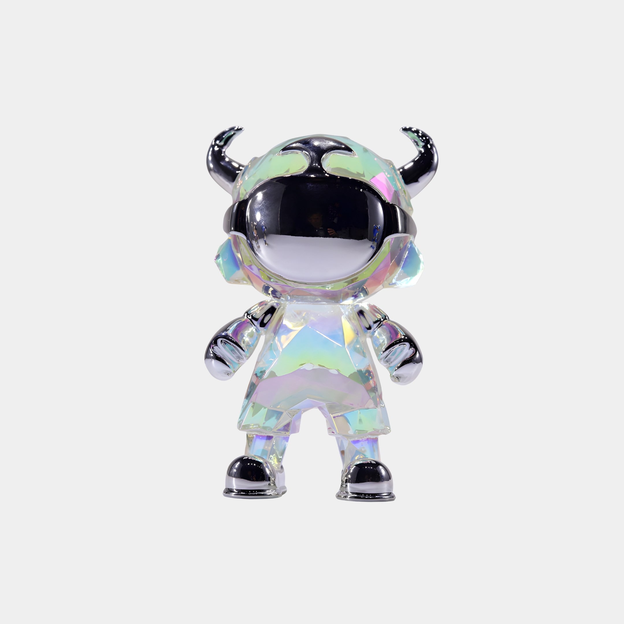 The Giant Sculptures Iridescent Chrome Astro Devil Figure (15cm) features a shiny, horned helmet, visor, and boots. This unique astronaut-inspired designer sculpture stands against a white background.