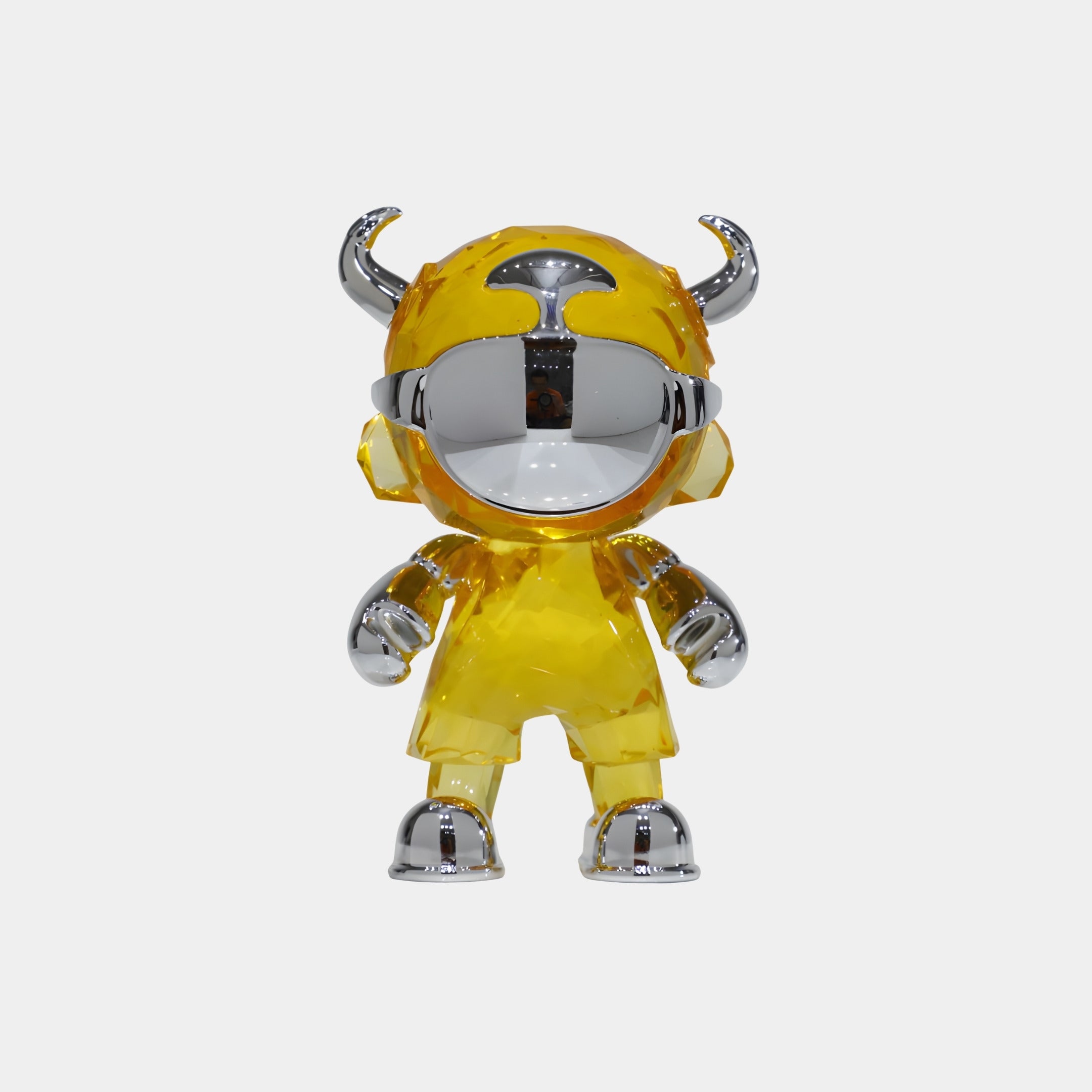 The Giant Sculptures Solar Yellow Chrome Astro Devil Figure - 15cm features an astronaut-inspired design with horns, a large reflective visor, and chunky limbs, shown standing upright against a plain white background.