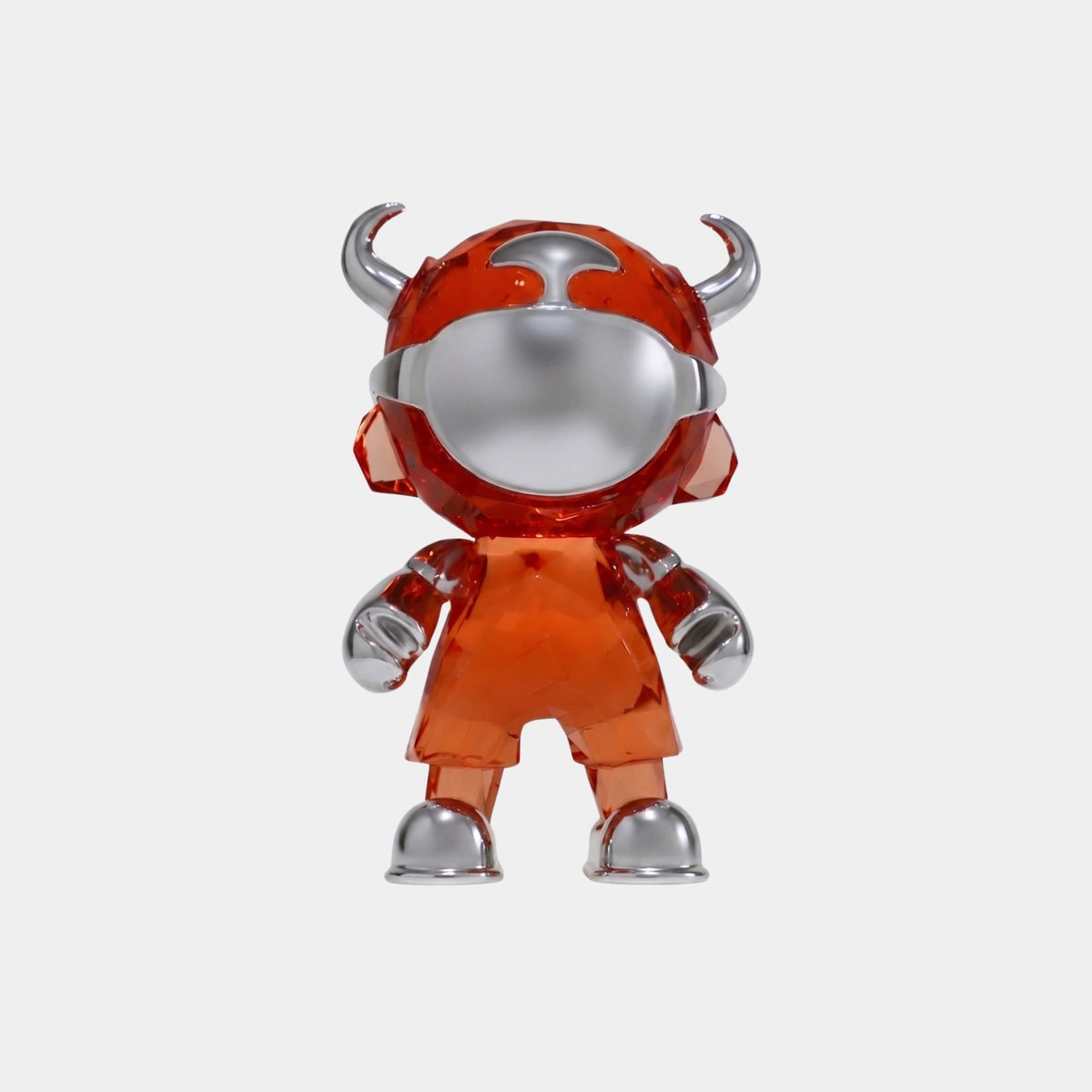 The Blaze Orange Chrome Astro Devil Figure - 15cm by Giant Sculptures is a designer toy with a shiny silver face, hands, and feet, wearing a translucent orange suit with helmet horns, set against a plain white background.