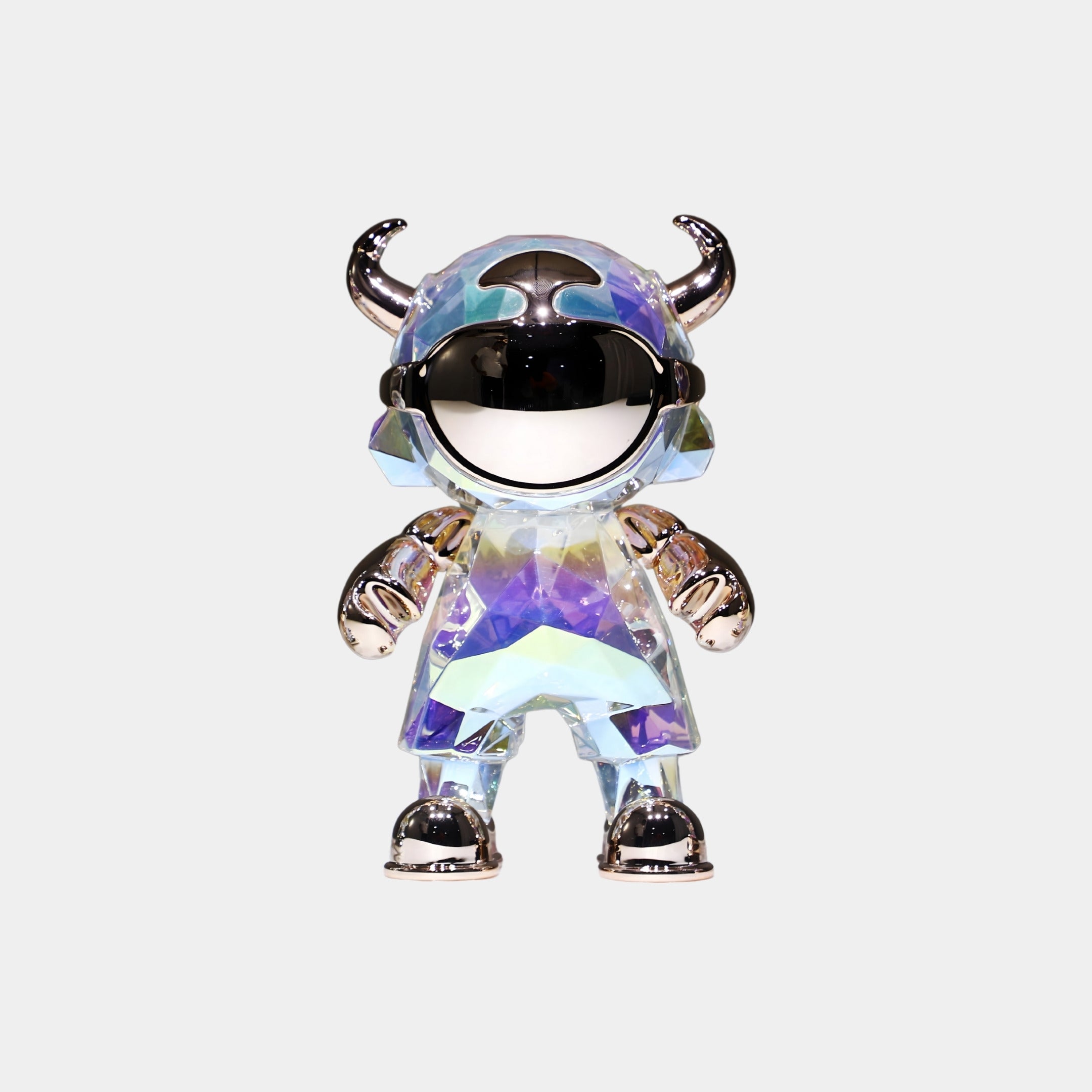 The Aurora Prism Astro Devil Figure (21cm) by Giant Sculptures features an iridescent chrome finish, horned helmet, mirrored visor, and metallic gloves and boots—an eye-catching collectible art toy on a plain light background.
