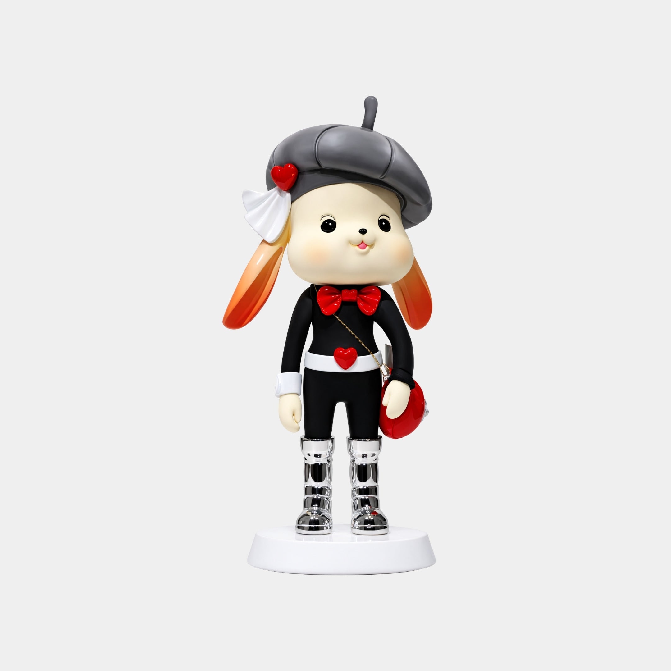 The Monochrome Rouge Bunny Figure - 58cm by Giant Sculptures is a collectible with orange ears, a black beret, black and white outfit with red accents, shiny silver boots, red bow tie, small red purse, and stands on a white base.