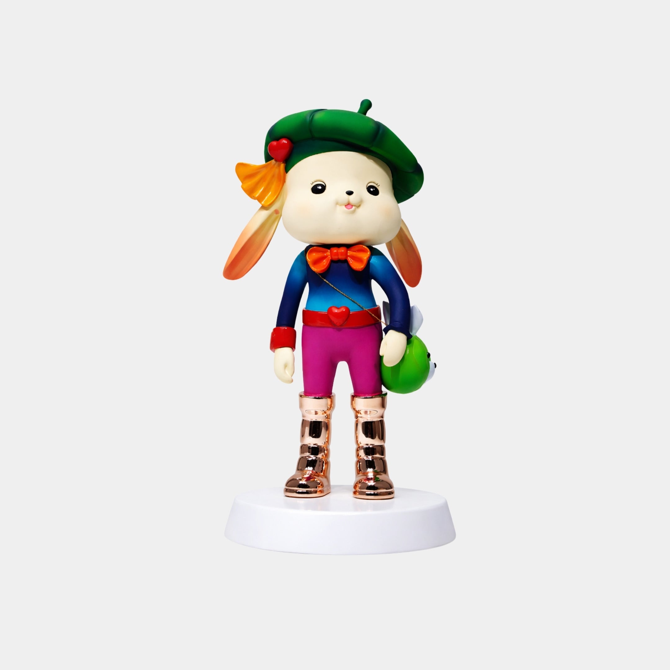 The Royal Pop Bunny Figure - 58cm by Giant Sculptures is a cute bunny in colorful clothes—green beret with flower, blue top, red bow tie, pink shorts, and gold boots—standing on a white circular base.