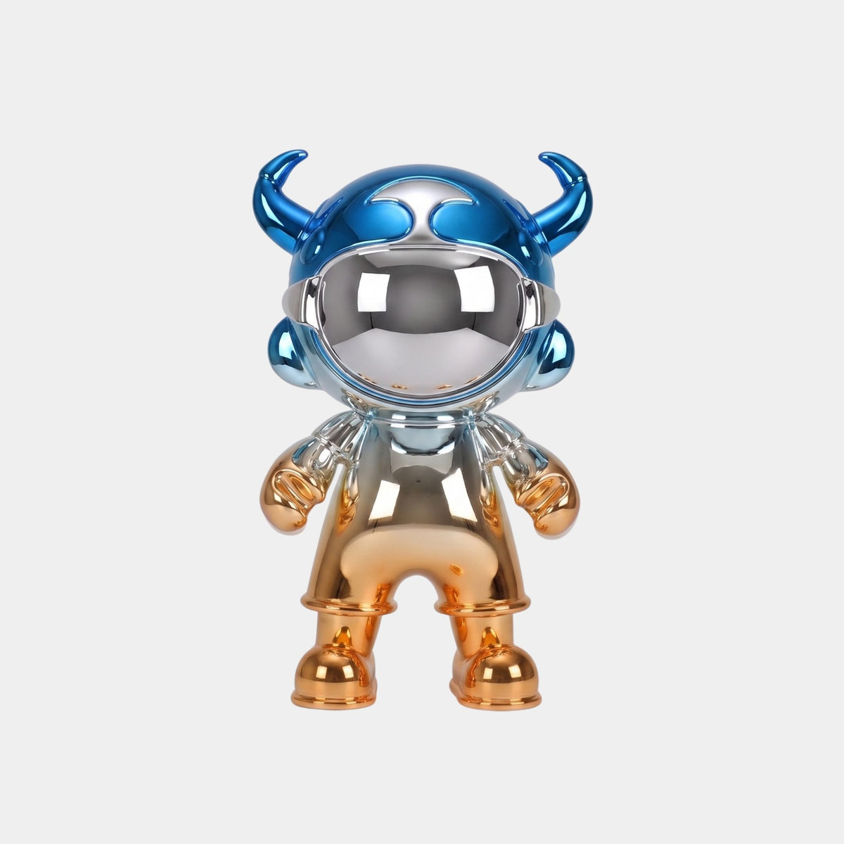 A shiny humanoid figure with a mirrored visor, blue horned helmet, and gold hands and boots stands on a plain background. The Blue & Copper Electroplated Astro Devil Figure - 35cm by Giant Sculptures shows visible human reflections.