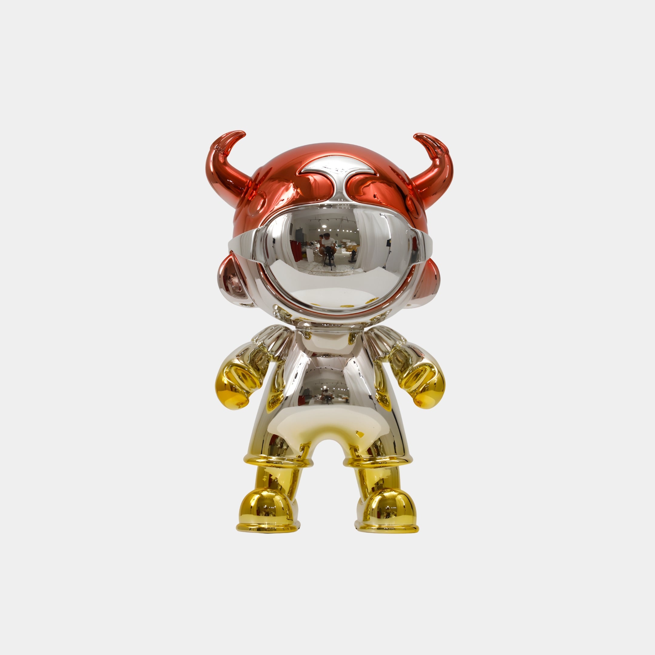 The Crimson & Gold Electroplated Astro Devil Figure - 35cm by Giant Sculptures features a shiny, reflective finish, red horned helmet, silver body, and gold hands and feet, standing upright like collectible art against a white background.