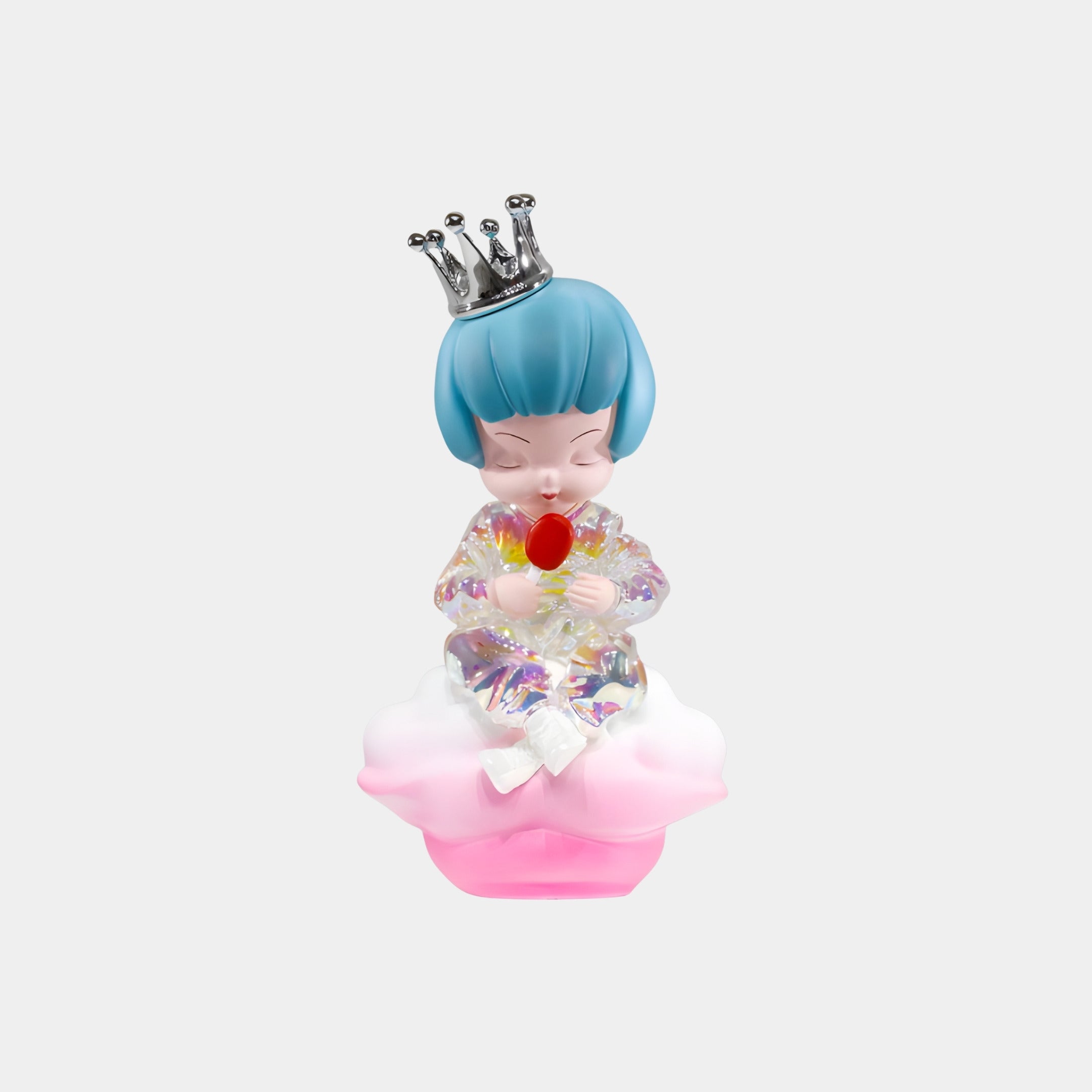 The Sky Crown Cloud Dreamer Figure - 35cm by Giant Sculptures is a 3D-printed resin sculpture of a blue-haired child in an iridescent outfit with a silver crown, sitting on a pink cloud and holding a red lollipop against a white background.