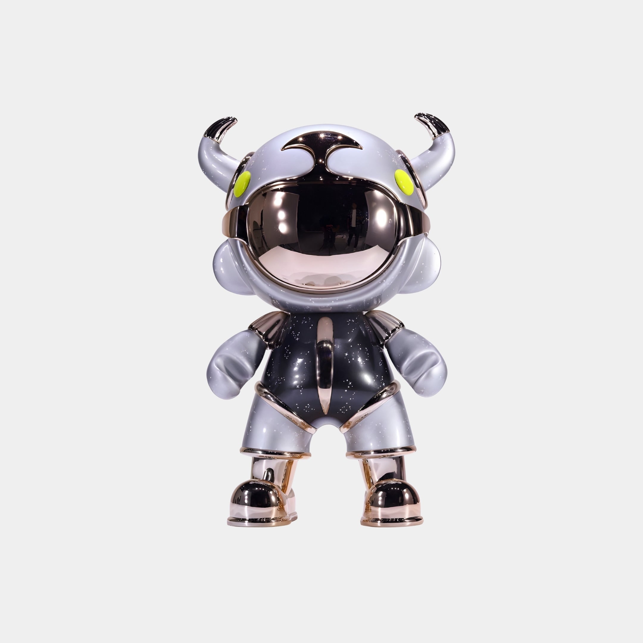 The Giant Sculptures Steel Grey Suit Astro Devil Figure (31cm) features metallic silver and gold armor, a horned helmet, and yellow eyes—crafted from eco-friendly resin and displayed against a plain white background.